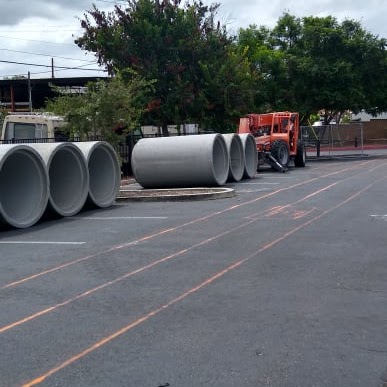 Reinforced concrete pipe staged for storm drain installation